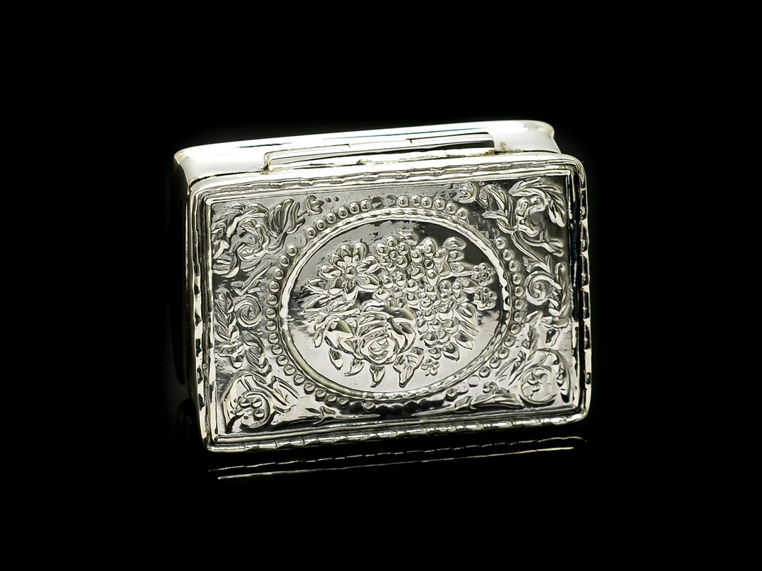 DOSA, silver, blomdekor i relief, 1x2,6x3,8 cm. — Silver/Övrigt — Kaplans