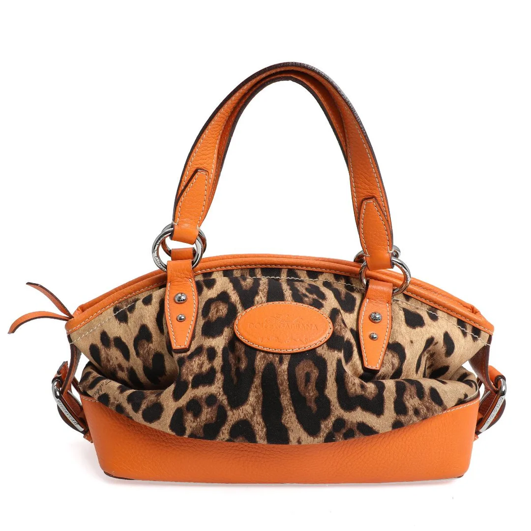 A bag of leopard print canvas with orange leather trimmings, silver tone hardware, two handles, one compartment with zipped pocket and dark brown lining. H. 20. W. 30. D. 15 cm. — Designer Handbags & Fashion — Bruun Rasmussen