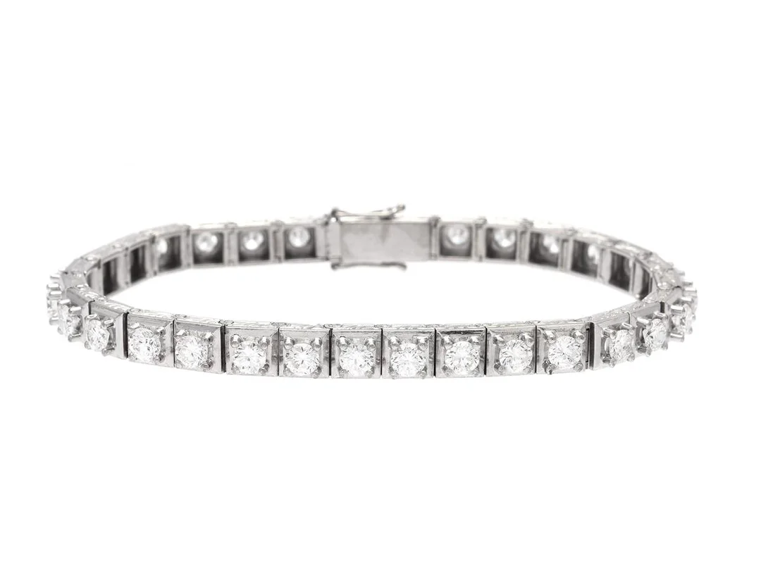 TENNISARMBAND, 18K vitguld, 31 briljantslipade diamanter ca 5,00 ctv, ca TW-CR/VS-P, längd 17,5 cm, vikt 30,6 g, några diamanter med skador och nagg. — Smycken/Tennisarmband — Kaplans