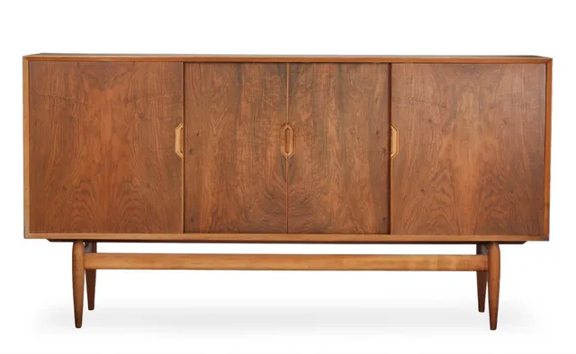 Walnut sideboard, front with four sliding doors behind which shelves, drawers and pull-out trays with visible joinery. Manufactured by Brande Møbelindustri. 1960s. H. 105. W. 200. D. 45.5 cm.