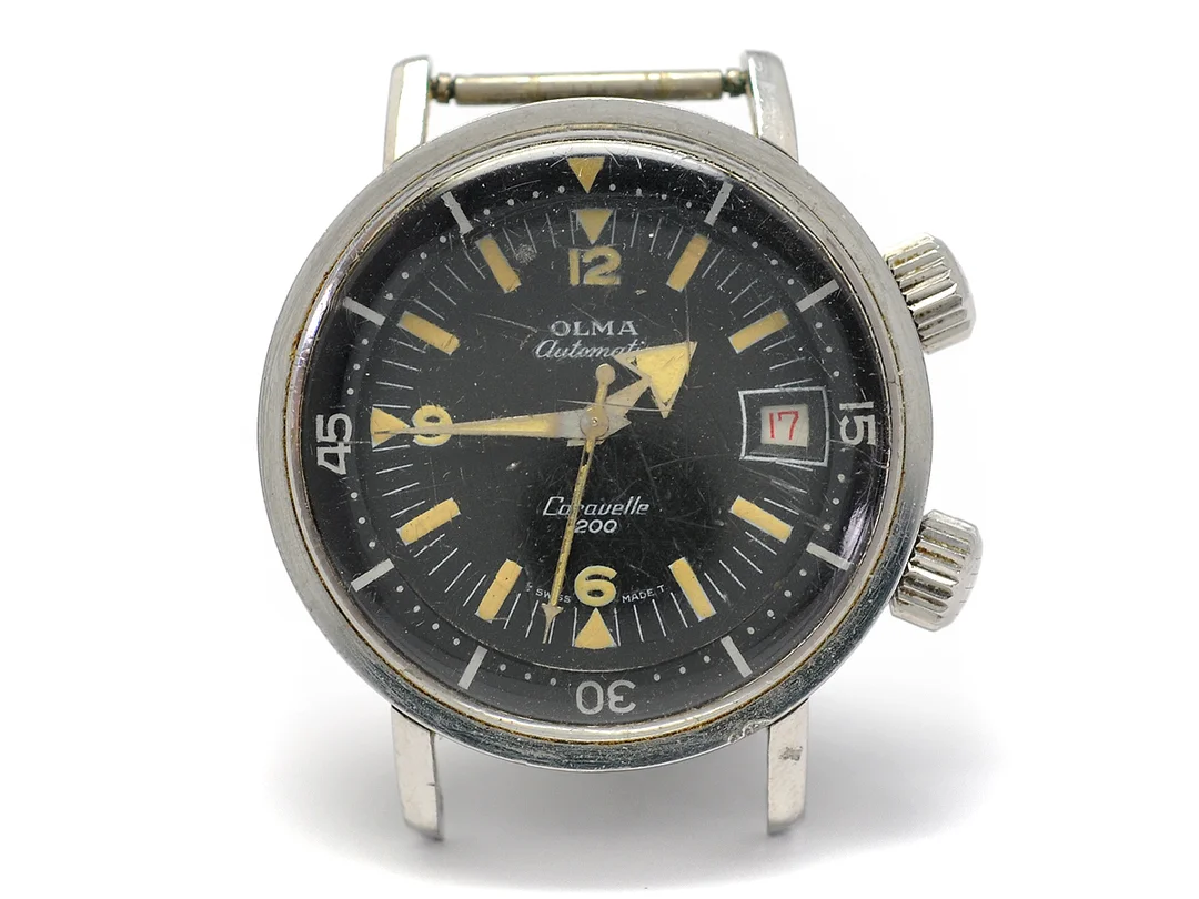 OLMA, Caravelle 200, Cal AS 1902, Boett nr. 0748/3, herrur, 36 mm, stål, automatisk, plexiglas, datum, vridbar innerring, skadad urtavla, defekt, ca 1965. — Klockor/Olma — Kaplans