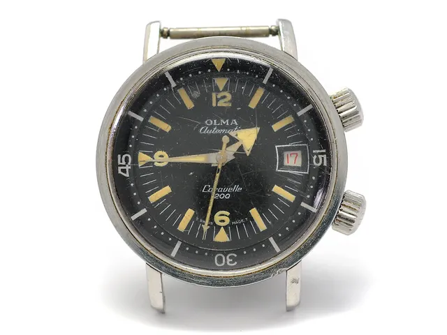 OLMA, Caravelle 200, Cal AS 1902, Boett nr. 0748/3, herrur, 36 mm, stål, automatisk, plexiglas, datum, vridbar innerring, skadad urtavla, defekt, ca 1965.