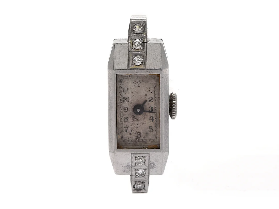 DAMUR, 10 x 23 (31) mm, Boett nr. 864984, stål (staybrite), manuell, plexiglas, skadad urtavla, formverk, diamanter på boetten (6 st. 8/8, en skadad), ca 1940. — Klockor/Övriga klockor — Kaplans