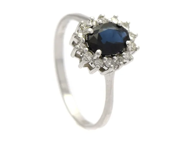 CARMOSÉRING, 18K vitguld, blå safir ca 1,05 ct, 14 briljantslipade diamanter ca 0,20 ctv, stl 17,25+ mm, vikt 2,5 g, 4 diamanter med nagg/skador.