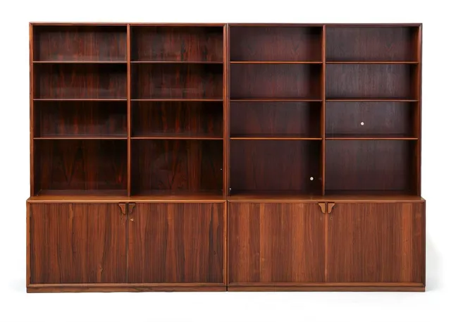 Wall unit of rosewood, consisting of two sections with bookcase and cabinet with profiled doors, behind which room for shelves. Manufactured for Illums Bolighus. H. 180 cm. W. 130 cm. D. 43 cm.