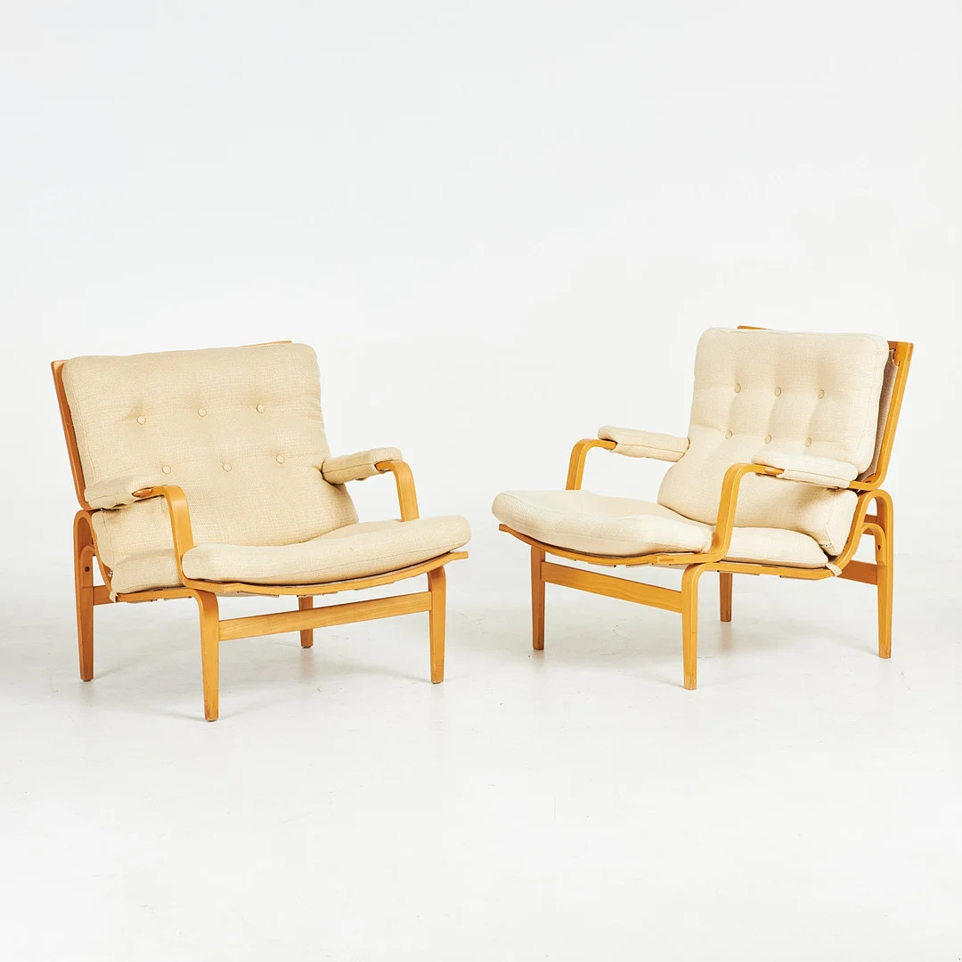 BRUNO MATHSSON. Fåtöljer, 1 par, "Ingrid", Dux, skiktlimmad stomme i bok, canvas, löst liggande plymåer, klädda knappar. — Armchairs & Chairs — Stockholms Auktionsverk Sickla