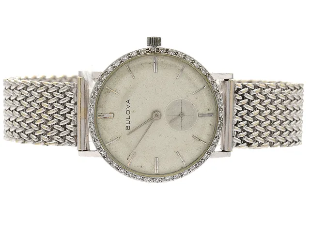 BULOVA L6 i vitguld 14K, manuell, cal. 10BM, med diamanter 44Xca0,01ct, plexiglas (lite repigt), separat sekundvisare, armlänk i 14K, Ø32,5mm, Intyg på diamanterna i klockan medföljer, från 1900 talets tidigare hälft