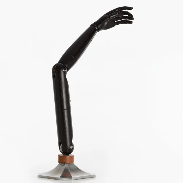 HANDMANNEKÄNG / DISPLAY. Ledad arm i svartlackerat trä på sockel i vitmetall. Art Deco-stil.