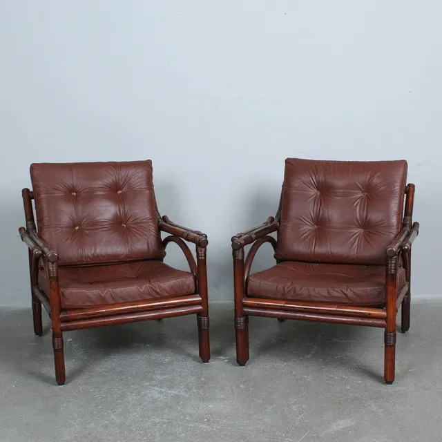 Paar Lounge-Sessel aus gebeiztem Bambus und Rattan mit braunen Lederpolstern.