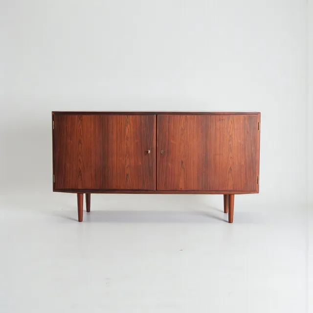 CARLO JENSEN. Lav skænk af palisander, front med to låger, bag hvilke hylder og udtræksbakker. Udført og mærket hos Hundevad & Co. Danmark, 1960'erne.