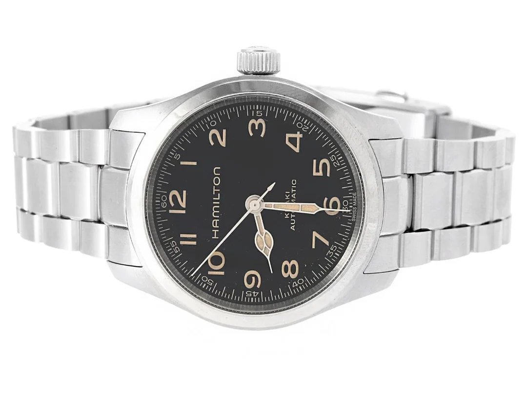 HAMILTON, Khaki Field, "Murph", Cal H10 (ETA C07611), Serie nr. 0L2GS7C0U, Ref nr. H70405130, Boett nr. H704050, herrur, 38 mm, stål, automatisk, safirglas, glasbaksida, originallänk, viklås, cert, juli 2025, box, ytterkartong. — Klockor/Hamilton — Kaplans