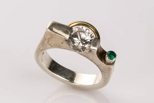 Ring af platin med cubisk zirkonia og smaragd af 14 kt guld