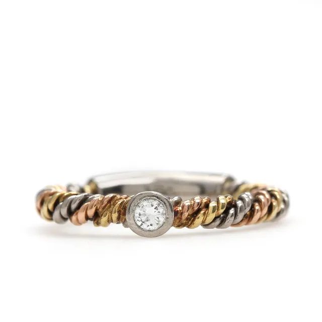 A twisted diamond ring set with a brilliant-cut diamond weighing app. 0.08 ct, mounted in 18k gold, red and white gold. Weight app. 4 g. Size 52.