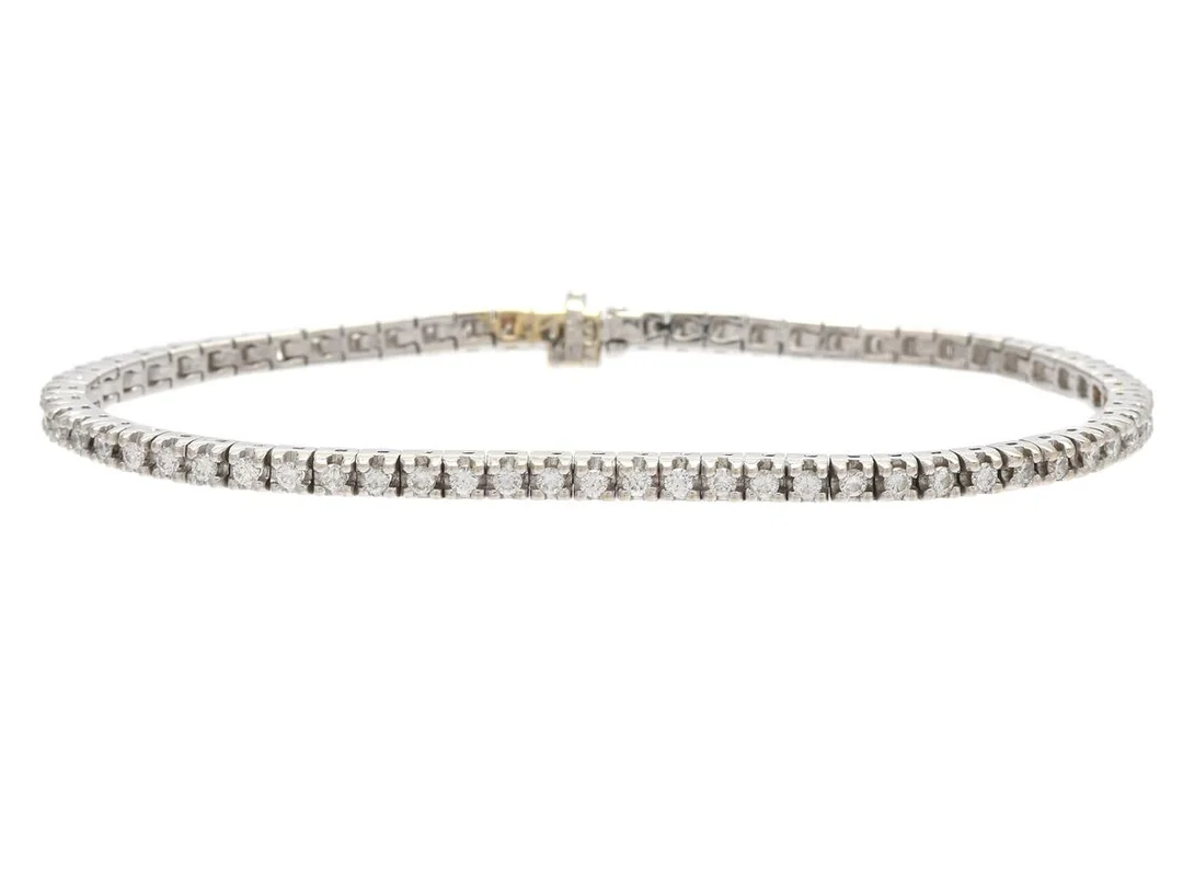 TENNISARMBAND, vitguld, briljantslipade diamanter ca 1,32 ctv, ca TW/VVS, längd 17 cm, vikt 12,3 g, ett par diamanter med skador. — Smycken/Armband — Kaplans