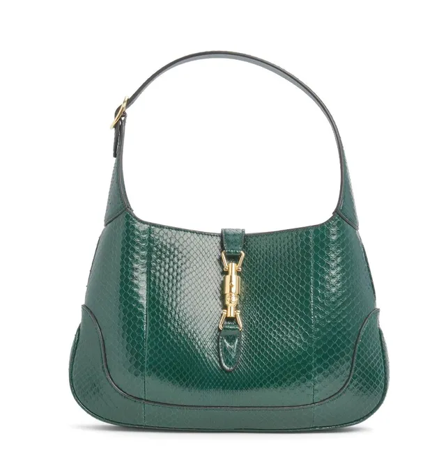 A “Jackie 1961” bag of dark green snakeskin with gold tone hardware, adjustable handle, one compartment with one interior zipped pocket, two flat card pockets and rose coloured leather lining. H. 22 x W. 33 x D. 4 cm.