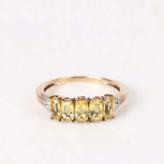 A 9 CARAT GOLD, YELLOW QUARTZ AND DIAMOND RING.