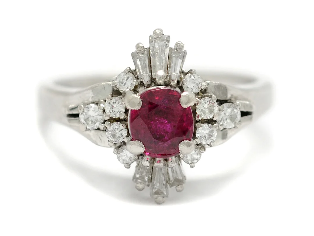 RING, platina, rubin ca 0,78 ct (inneslutning som når ytan), 10 briljanter och 6 baguetter ca 0,47 ctv, ca TW/VS-SI (1 P1, 3 små nagg), stl 17 mm, vikt 7,9 g. — Smycken/Ring — Kaplans