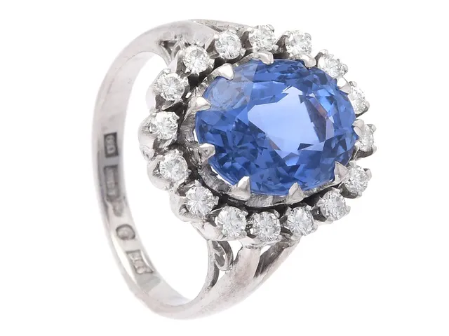 CARMOSÉRING, silver, ovalslipad safir ca 5,80 ct, 16 briljantslipade diamanter ca 0,50 ctv, ca TW-W/SI-P, stl 17,25 mm, vikt 6,2 g, senare ringskena i 18K vitguld från Stockholm 1970, safiren och en diamant har nagg på kuletten.