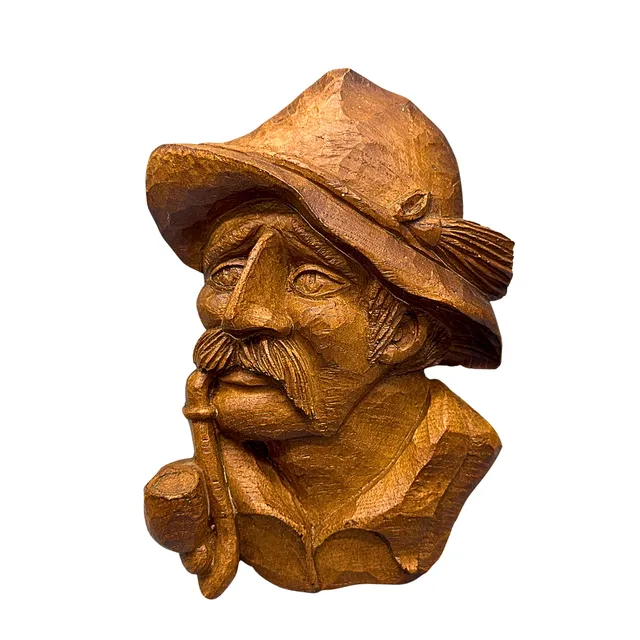 WANDMASKE AUS HOLZ VON EINEM JÄGER MIT PFEIFE.