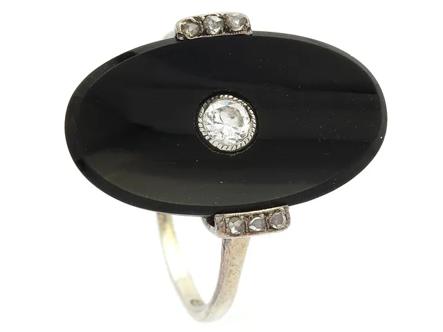 Ring, 18K vitguld, onyx, gammalslipad diamant ca 0,12 ct, 6 rosenslipade diamanter, stl 17 mm, vikt 3,2 g.