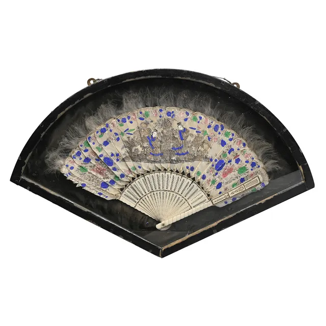 A CHINESE PIERCED BONE AND PAINTED FEATHER BRISE FAN, 19TH CENTURY, IN GLAZED DISPLAY CASE.