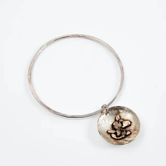 ROSA TAIKON (1926-2017), armring, sterlingsilver, Trollbäcken 1972, hamrad dekor, skålformat hänge, invändigt förgylld.