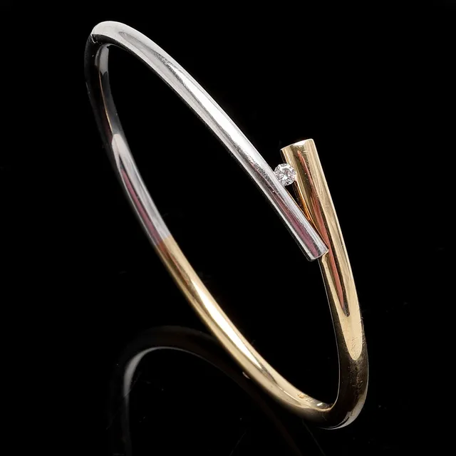 ARMRING, 14 K guld/vitguld. Briljant ca 0,10 ct. Vikt ca 25,4 gram.