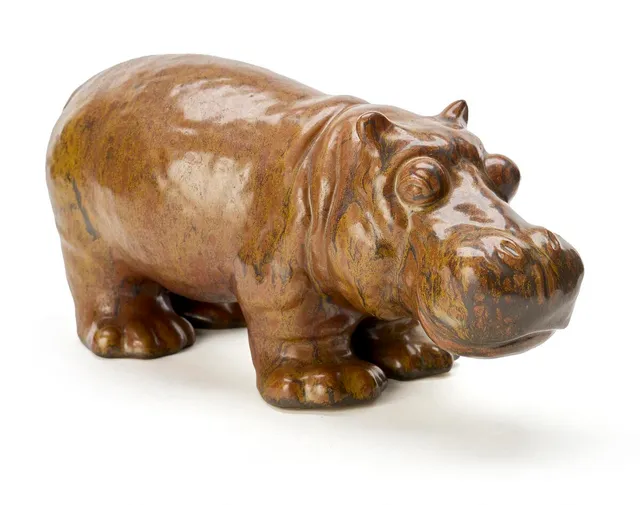 Stoneware figure modelled as a hippopotamus, decorated with a yellowish-brown glaze with darker elements. Made by L. Hjorth, Denmark, 610. H. 15 cm. L. 35 cm.