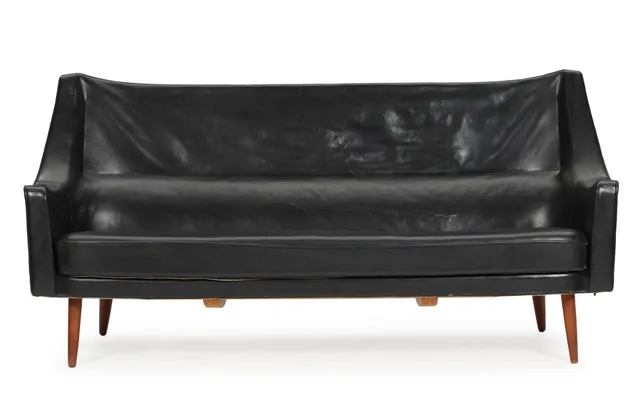 Three-seater sofa with teak legs, upholstered with original black leather. Designed in 1954. Manufactured by Harald Gjernøe or Chr. Sørensen & Co. 1950s. L. 185 cm.
