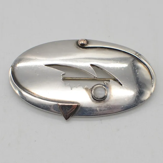 DURCHBROCHENE DESIGNERBROSCHE AUS STERLINGSILBER, MONDSTEIN-CABOCHON, VERGOLDETE DETAILS, UNBEKANNTE MEISTERPUNZE, UM 1950.