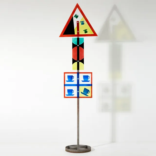 ÅSA BRANDT. Skulptur, Torshälla 1995, i form av ett trafikmärke, planglas och fusing, dekor av kaffekoppar.