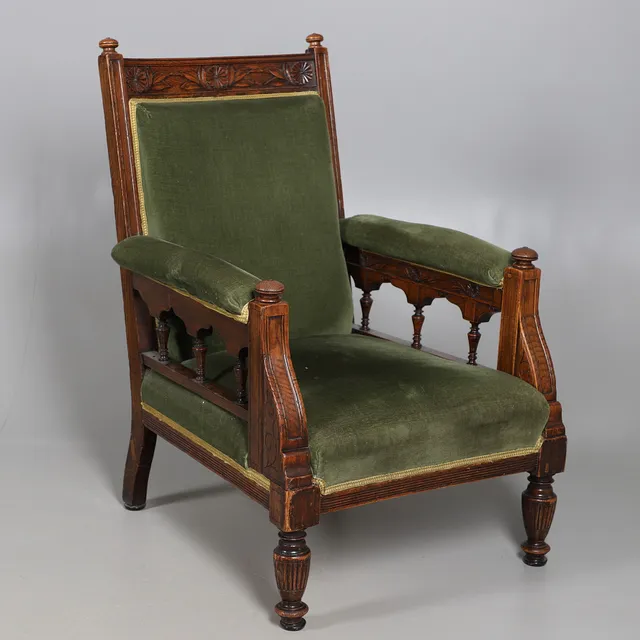 A LATE VICTORIAN AESTHETIC MOVEMENT CARVED OAK OPEN ARMCHAIR.