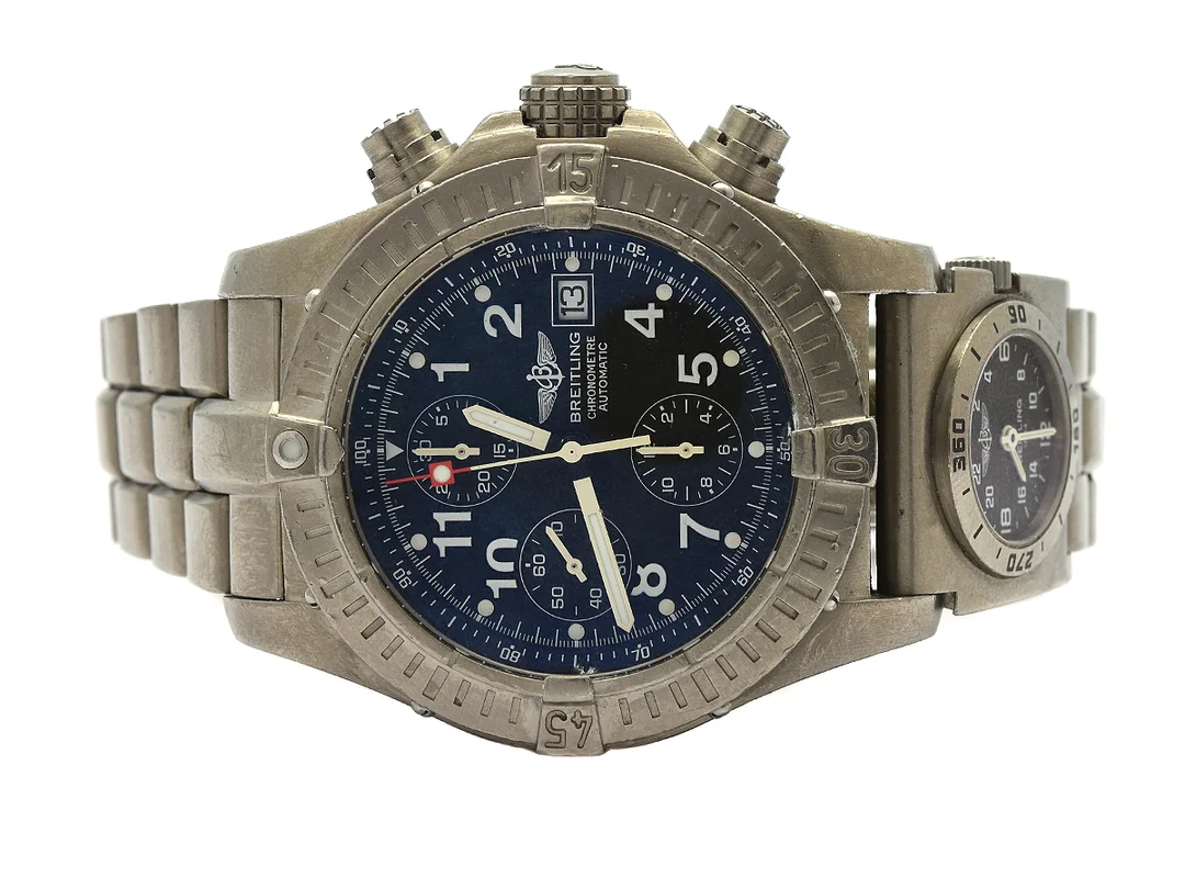 BREITLING, Chrono Avenger, Chronometre, Cal 13 (ETA 7750), Verk nr. 2068163, Serie nr. 2068163, Ref nr. E13360, Boett nr. 4305 B5, kronograf (tryckknapp trög), herrur, 44 mm, titan, automatisk, safirglas, datum, UTC, Serie nr. 0798, Ref nr. E70176, titan, quartz, safirglas, 24-timmarsvisning, skadad urtavla, Professionallänk I, viklås, Ref nr. 2303/885E, ca 2005, box, ytterkartong. — Klockor/Breitling — Kaplans