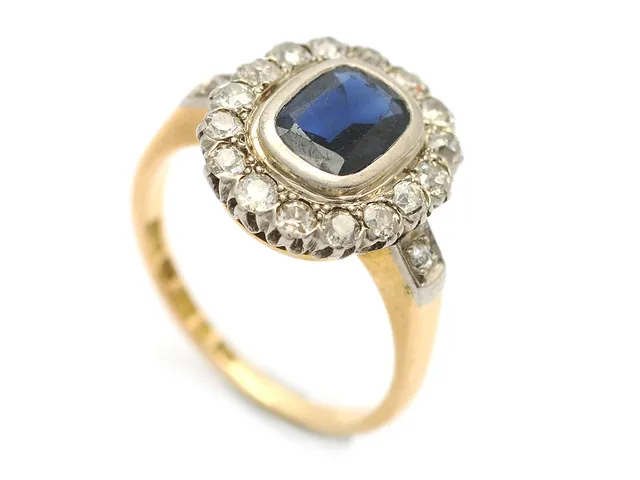 CARMOSÉRING, 18K guld, blå safir, 18 äldre åttkantslipade diamanter ca 0,52 ctv, ca W/SI-P, Petterssons Eftr Juvelerar Ab, Stockholm 1947, stl 18 mm, vikt 6 g, slitna fasettkanter på safiren, nagg, 1 diamant skadad.