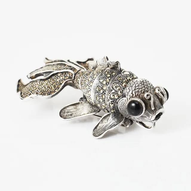 BROSCH/HÄNGE, silver, dekor med markasiter och cabochonslipade svarta stenar till ögon, i form av en s.k. koi fish, delvis ledad.