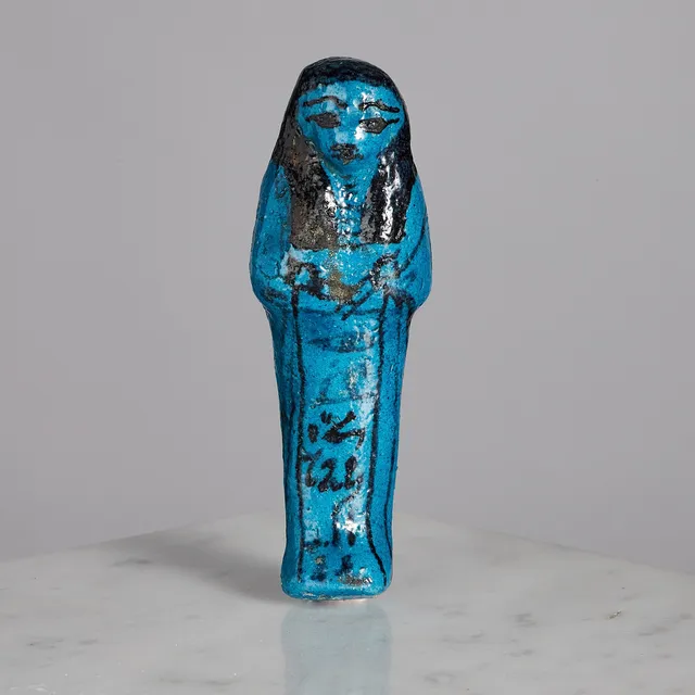 USHEBTI, Egypt, 21st Dynasty (1069-943 BC). Blue cobalt-glazed faience for the scribe Pa-kati (name and titles written in hieratic). H: 10cm. Provenence: Lennart Diener. Old label on reverse ” XXI dynasty inscribed with name of Pakkati scribe”.