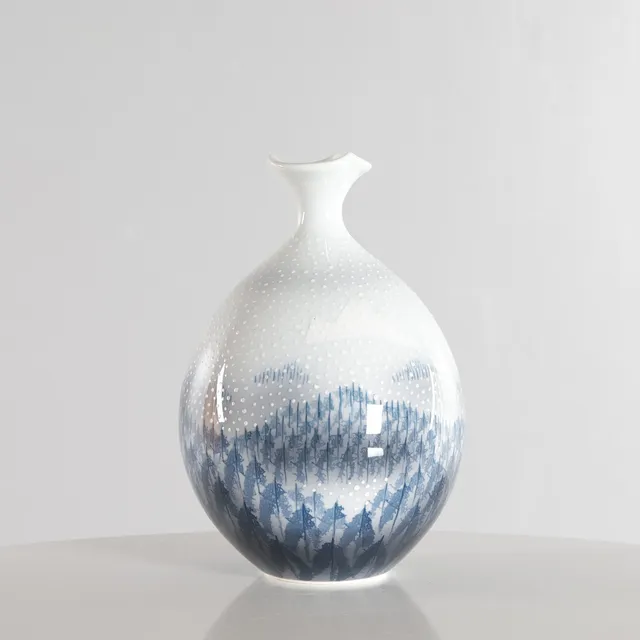 FUJII SHUMEI (1936–2017). En vintage japansk Arita-porcelænsvase. Den rene hvide overflade er dekoreret med et håndmalet snedækket landskab fra Arita. Signeret af kunstneren i bunden. Japan, 1960–70’erne.