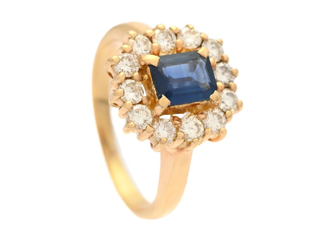 CARMOSÉRING, 18K guld, blå safir ca 0,75 ct, 12 briljantslipade diamanter ca 0,60 ctv, ca W-TCr/SI-P, stl 17,25+ mm, vikt 6,1 g, safir med mindre nagg. — Smycken/Carmoséring — Kaplans