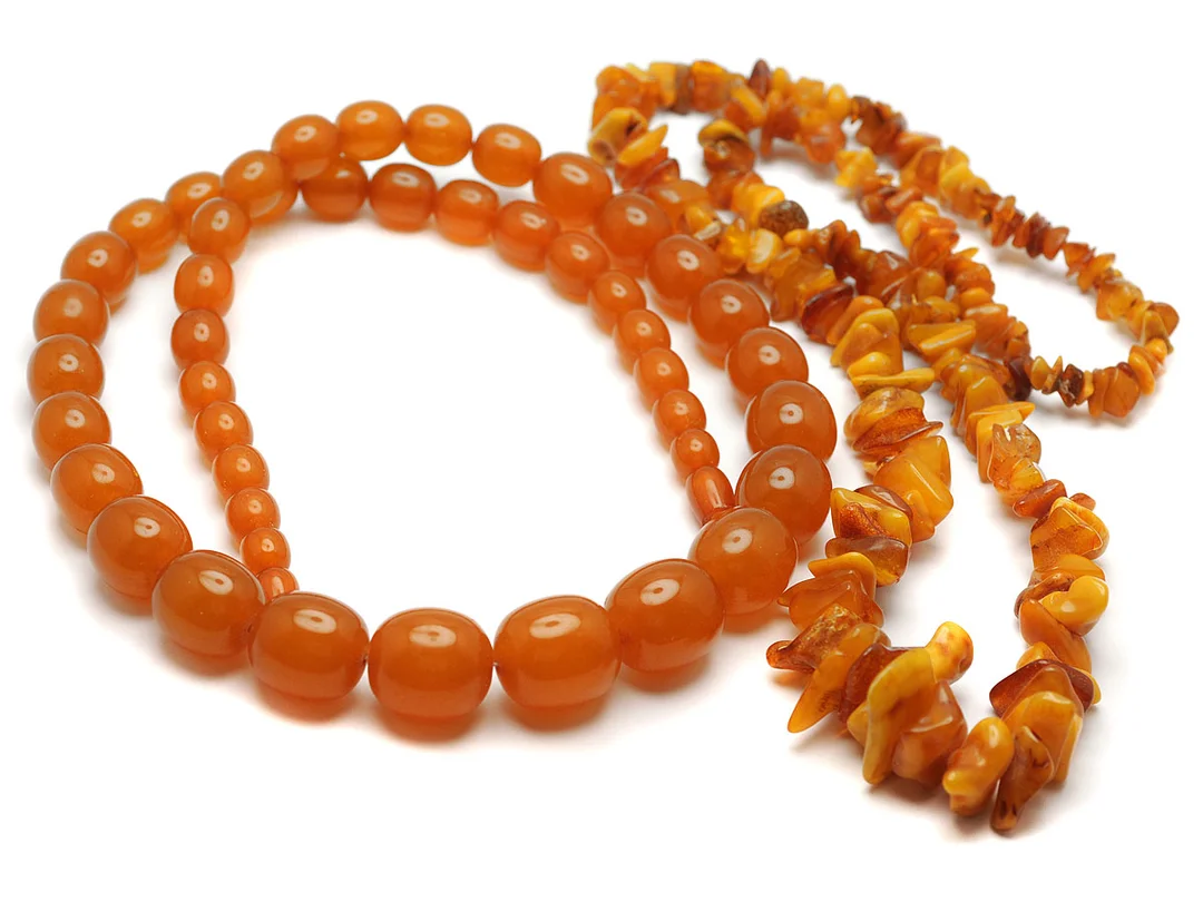 2 COLLIER, pressad bärnsten, ovala kulor ca 8,9-19 mm, längd 70 cm. Bärnsten, barock form, längd 70 cm. — Smycken/Collier — Kaplans