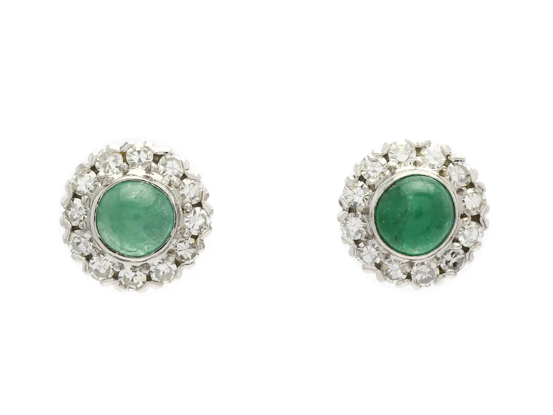 ÖRHÄNGEN, 18K vitguld, cabochonslipade smaragder ca 1,00 ctv, 24 åttkantslipade diamanter ca 0,60 ctv, ca TW-Cr(G-J)/VS-SI, vikt 4,2 g, stift, smaragderna har inneslutningar som når ytan, en diamant med natural vid rondisten och en med nagg på rondisten. — Smycken/Örhängen — Kaplans