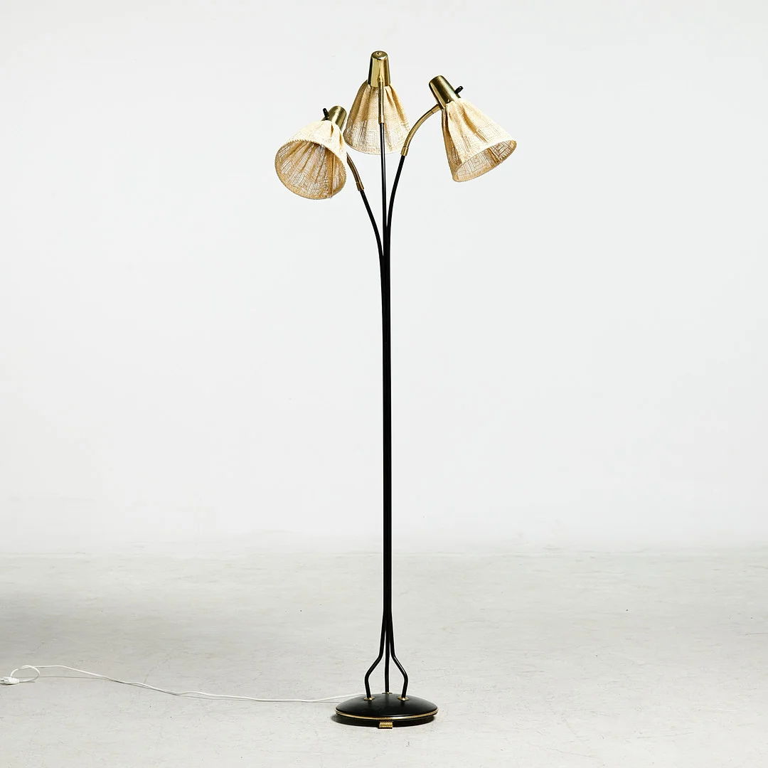 GOLVLAMPA, Eskilstuna Elektrofab. AB, 3-armad, stomme i svartlackerad metall, detaljer i mässing, textilklädda skärmar, stämpelmärkt i botten, ca 1900-talets mitt. — Floor lights — Stockholms Auktionsverk Sickla