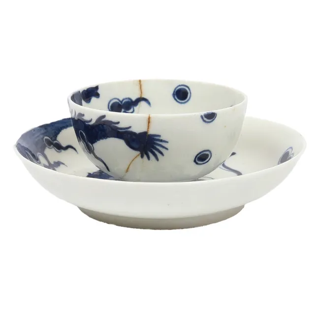 A LOWESTOFT DRAGON PATTERN TEA BOWL AND SAUCER.