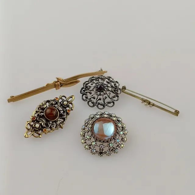 KONVOLUT 5 BROSCHEN, Modeschmuck, 20. Jh., unterschiedliche Ausführungen in silber- und goldfarbenem Metall.