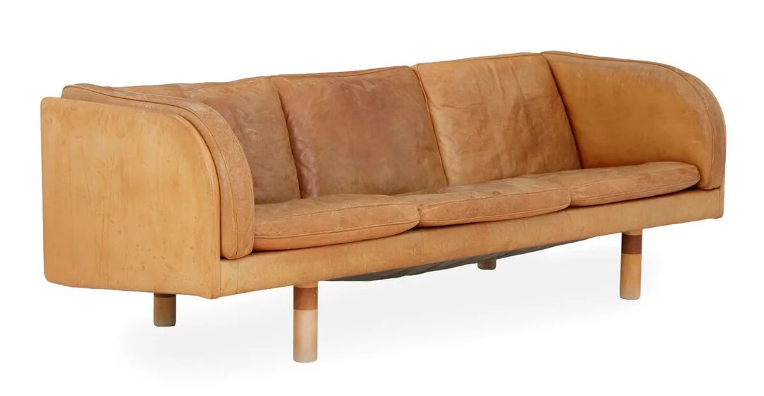 Three-seater sofa with legs of beech and mahogany. Seat, sides and back upholstered in patinated natural leather. EJ 20. Manufactured by Erik Jørgensen. L. 202 cm. — Modern Furniture — Bruun Rasmussen
