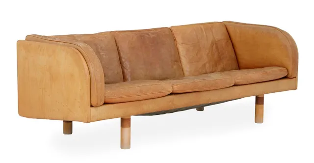 Three-seater sofa with legs of beech and mahogany. Seat, sides and back upholstered in patinated natural leather. EJ 20. Manufactured by Erik Jørgensen. L. 202 cm.