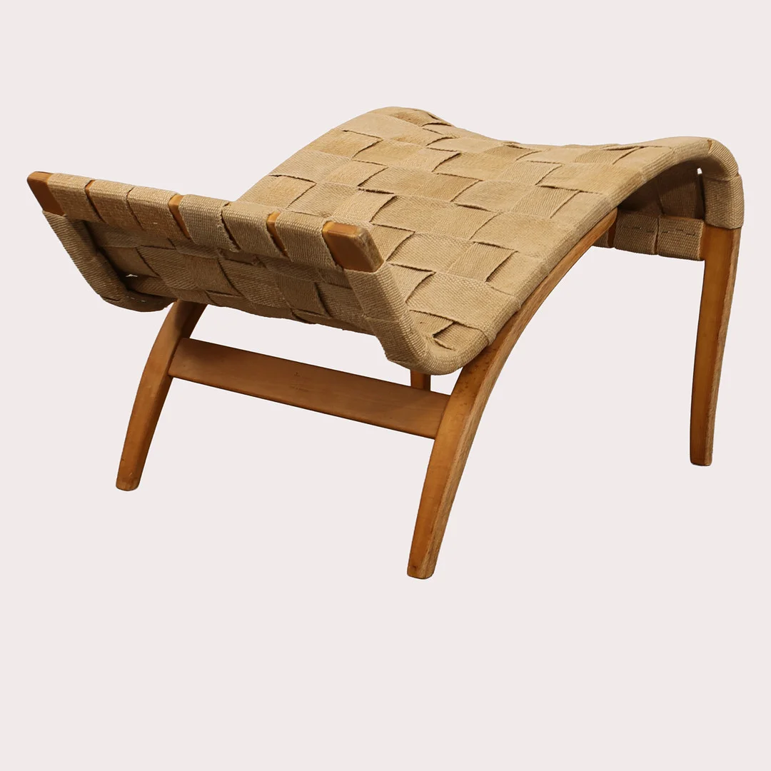 BRUNO MATHSSON. Fotpall, bok med flätad sadelgjord, "Pernilla", Dux, Värnamo, 1964. — Armchairs & Chairs — Limhamns Auktionsbyrå