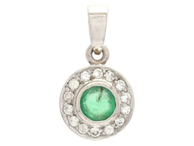 HÄNGE, 18K vitguld, smaragd ca 0,22 ct, 14 diamanter (13 briljantslipade och 1 åttkantslipad) ca 0,10 ctv, ca W-TCr/VS-SI, den åttkantslipade är skadad, vikt 1,4 g.