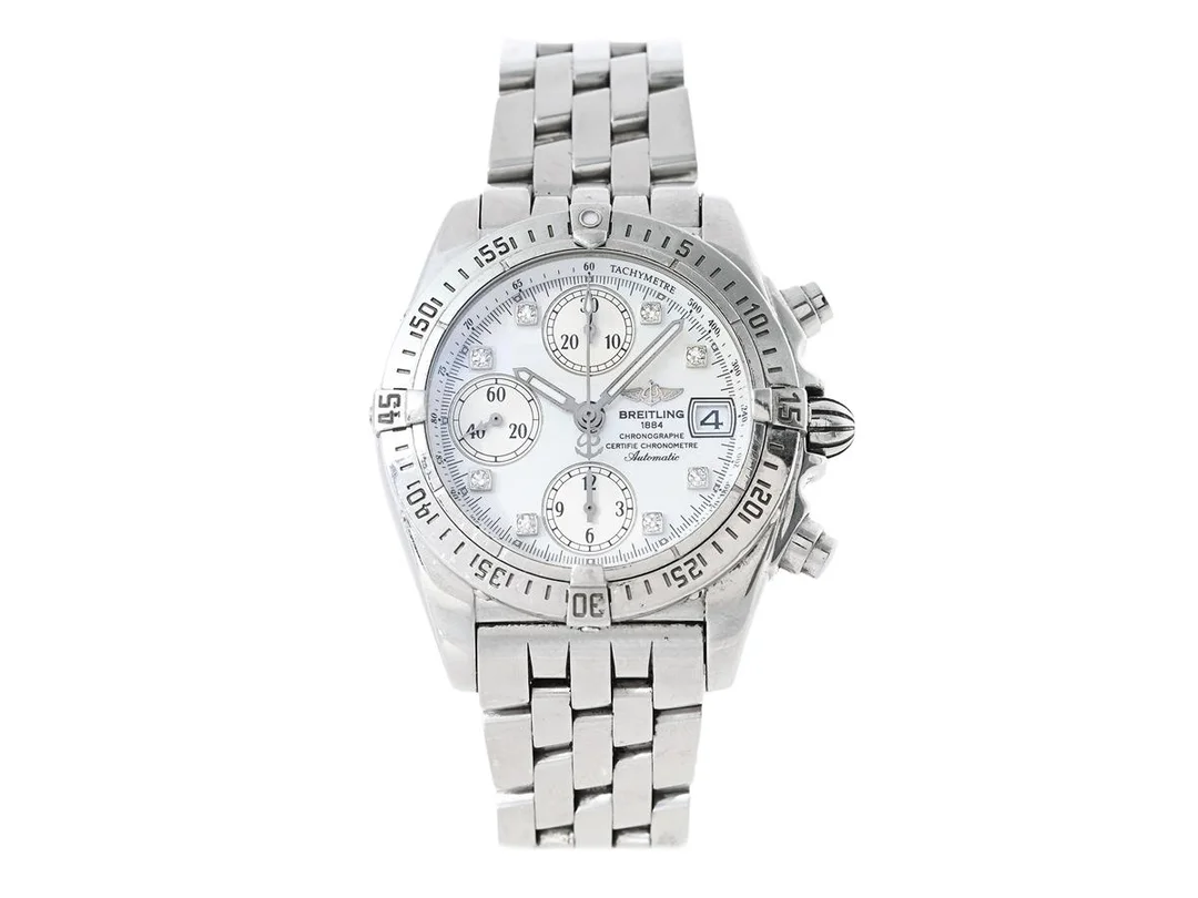BREITLING, Chrono Cockpit, "Tachymetre", Chronometre, Cal 13 (ETA 7750), Verk nr. 809513, Serie nr. 809513, Ref nr. A13357, Boett nr. 4104 B3, kronograf, unisex, 39 mm, stål, automatisk, safirglas (se fördjuapd info), datum, pärlemorurtavla med diamanter (8 st. 8/8), Pilotlänk, viklås, Ref nr. S 4604/358 A, cert, december 2006, box (ej komplett/skadad), ytterkartong, serviceetui. — Klockor/Breitling — Kaplans