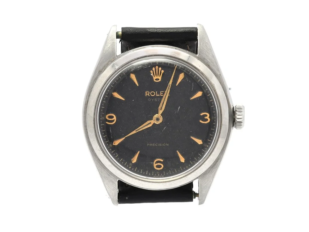 ROLEX, Oyster, Precision (Swiss), Ref nr. 6024, Serie nr. 866462, Cal 710, Verk nr. 69701, Boett nr. 6024, herrur, 36 mm, stål, manuell, plexiglas, saknar sekundvisare, skadad urtavla, defekt (går ej, akut servicebehov). bucklor bakboett, OBS: saknar 1 st. verkhållare, läderband, ca 1953. — Klockor/Rolex — Kaplans