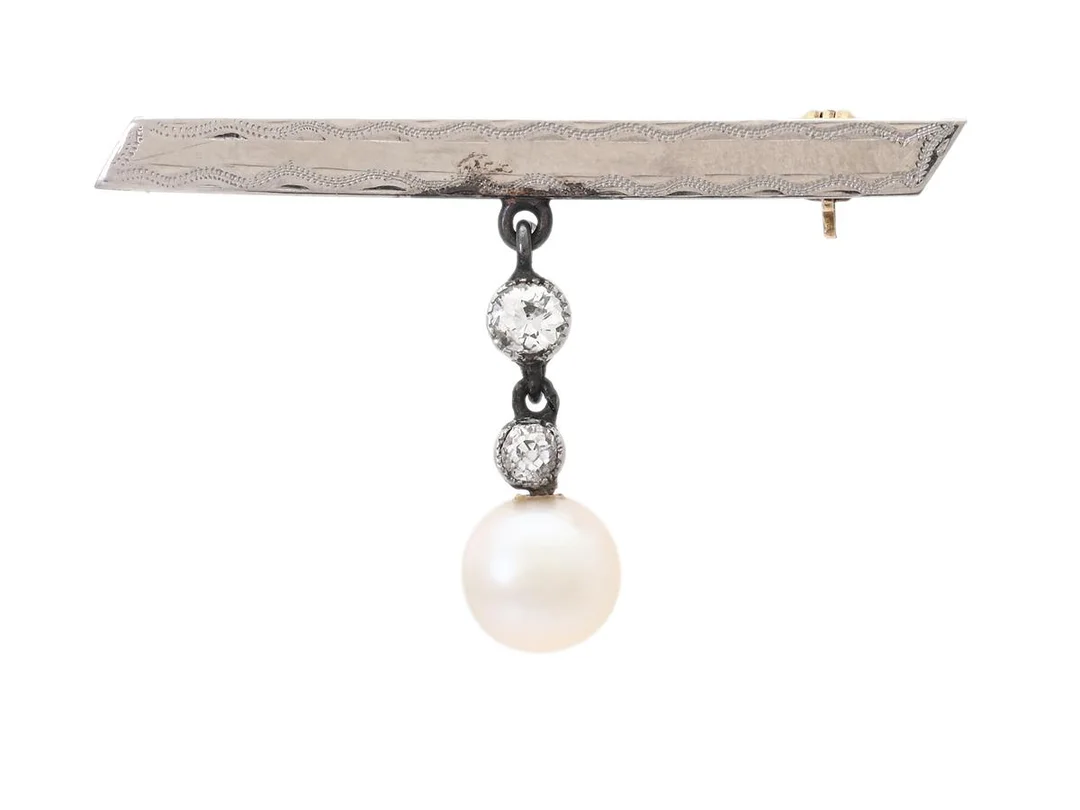 BROSCH, 18K guld/vitguld/platina, odlad pärla ca 7 mm, 2 gammalslipade diamanter ca 0,20 ctv, höjd 23 mm, vikt 3,3 g. — Smycken/Brosch — Kaplans